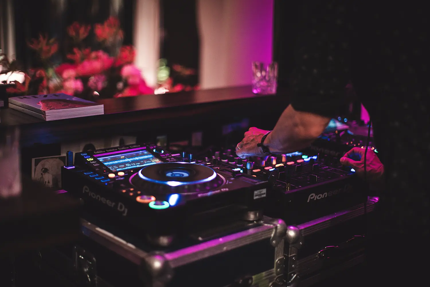 Pioneer DJ controller set up under pink and purple lighting