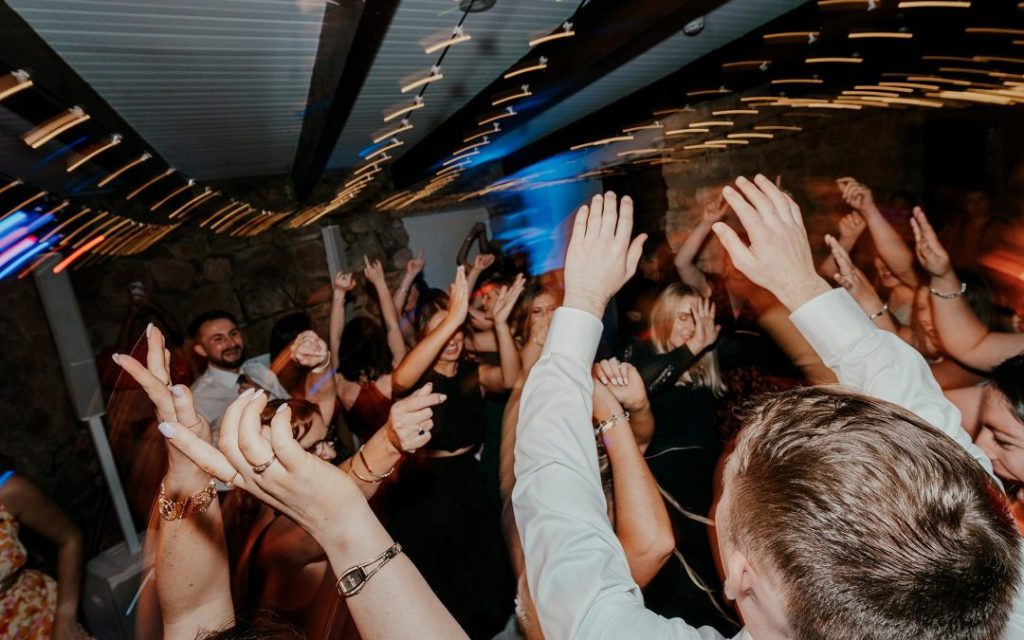 Crowd with hands raised on a packed dance floor